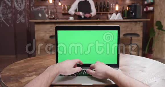 在带有绿色屏幕显示的笔记本电脑上打字的POV镜头视频的预览图