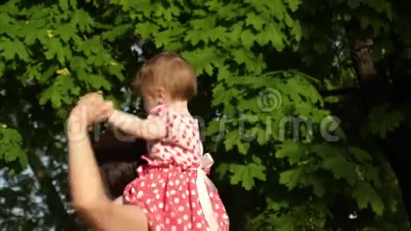 快乐的妈妈在夏天的公园里和她的小女儿肩上跳舞视频的预览图