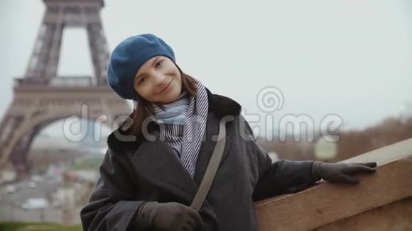 埃菲尔铁塔附近穿着蓝色贝雷帽和冬季外套的时尚女性肖像视频的预览图