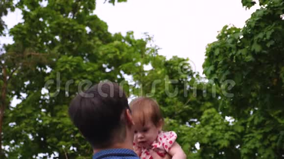 小孩子在父亲的手里跳到空中笑了爸爸夏天和女儿在公园玩慢慢视频的预览图
