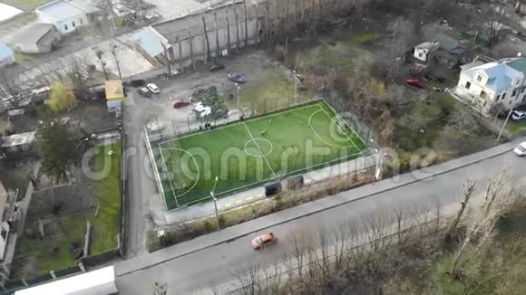 足球场地在城市中部设有人工草皮和围栏孩子们踢足球视频的预览图