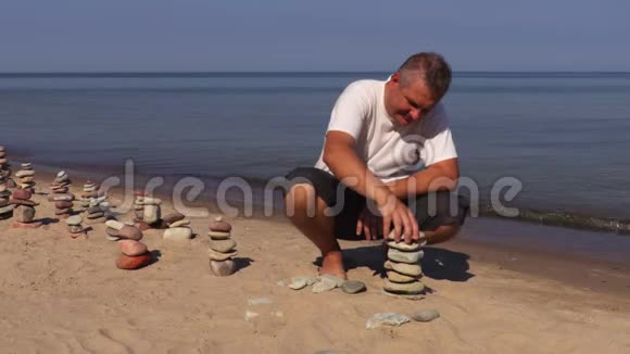 在海滩上建造石头金字塔视频的预览图