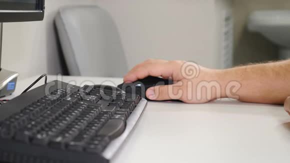 男性手点击电脑鼠标黑色键盘附近在牙科X线片柜里办公室概念关门视频的预览图