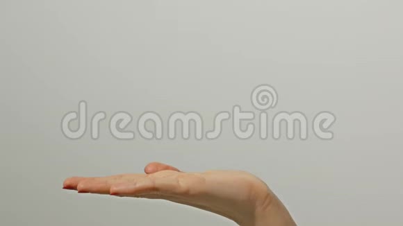 近距离观看1名女性成人伸出白种人的手在灰色背景上什么也拿不到年轻女子交视频的预览图