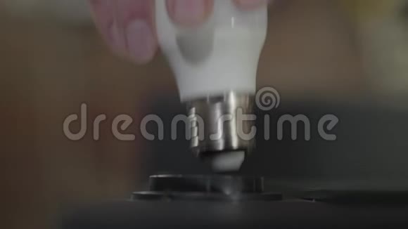 手拧灯泡内的灯和它的灯手工制造工匠在车间工作视频的预览图