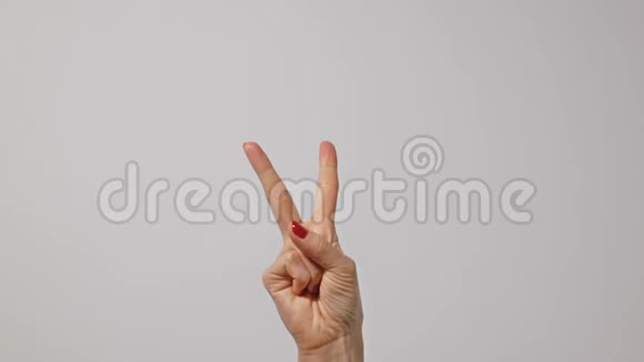 女人举起两个手指表示和平或胜利的象征或字母V女人一只手举起两个手指视频的预览图