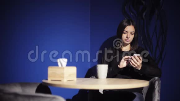 女孩在咖啡馆里用电话喝咖啡女人使用智能手机浏览阅读与朋友聊天视频的预览图