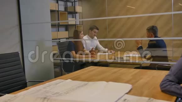 商务人士在现代办公室室内晚间讨论交易合同视频的预览图