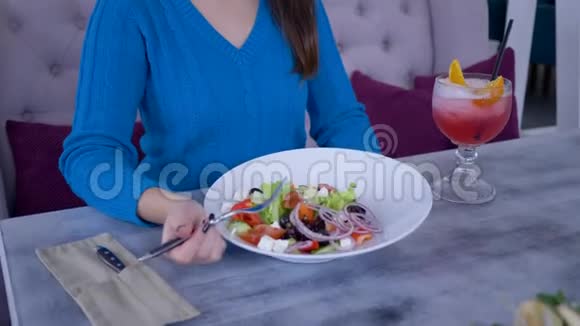 快乐的女人节食微笑的女人一边吃蔬菜晚餐一边从大盘子里吃漂亮有用的沙拉视频的预览图