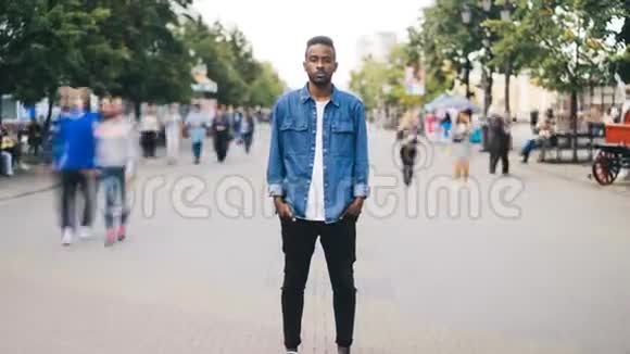 一个不幸的美国黑人男子独自站在市中心双手抱着短裤和视频的预览图