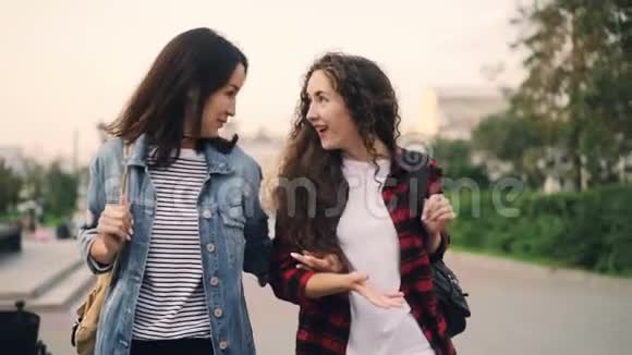 慢动作美丽的年轻女性游客在现代城市散步和欢笑一起享受暑假视频的预览图