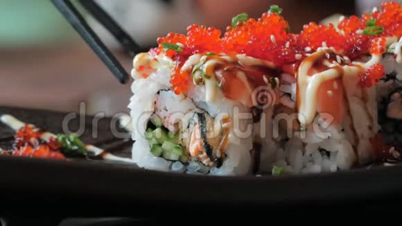 筷子的特写可以让寿司卷在盘子里在晒传统的日本料理视频的预览图