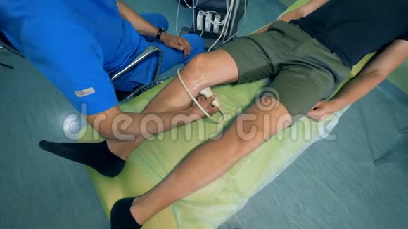 一位医生用超声波设备检查一个人膝盖4K视频的预览图