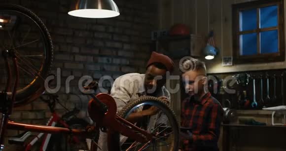男人教一个男孩自行车维修视频的预览图
