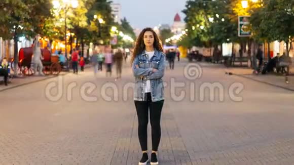 一位时髦的年轻女士厌倦了通常匆忙地站在街上在嗖嗖的人中间看着慢慢地消失了视频的预览图