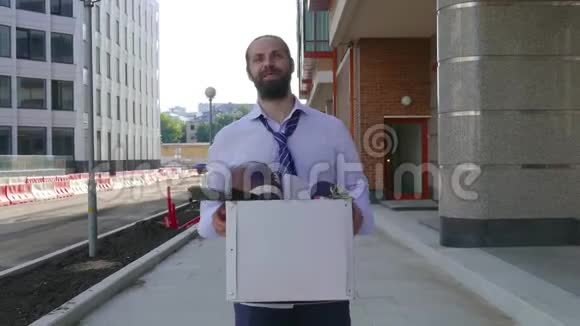 辞退观念招聘一名雇员带着纸板箱在办公楼之间行走视频的预览图