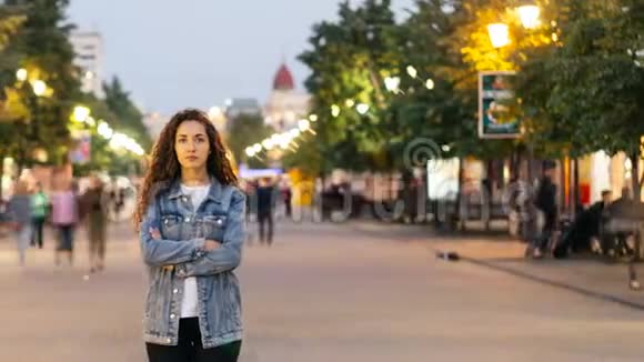 一幅时光流逝的照片孤独的年轻女子双臂交叉站在市中心的街道上而此时正是男人和女人的聚集地视频的预览图