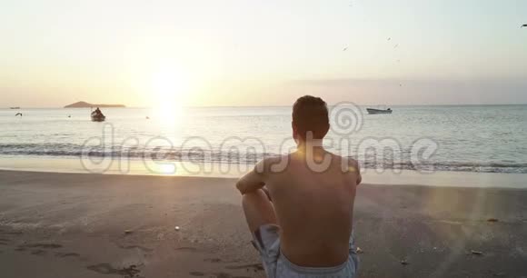 年轻的白种人在平静的海边放松迎接日出冥想自然视频的预览图