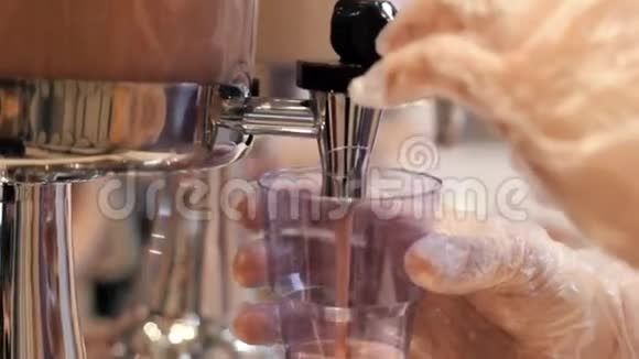 在自助餐厅工作的人把饮料倒在塑料杯里视频的预览图