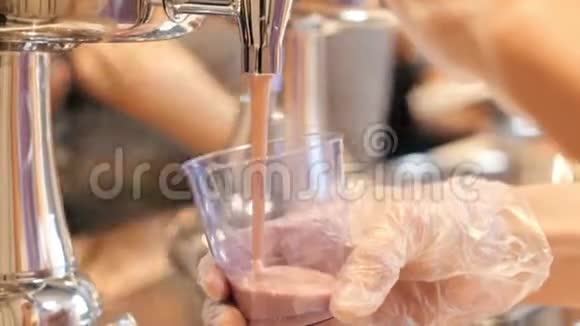 在自助餐厅工作的人在杯子里倒一杯粉红色的饮料视频的预览图