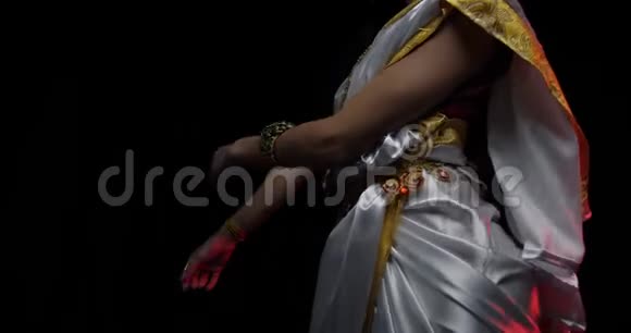 身着白色礼服金色珠宝黑色背景的跳舞印度女人视频的预览图