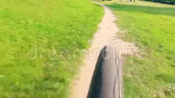 一辆自行车沿着公园小径快速行驶的后视镜视频的预览图
