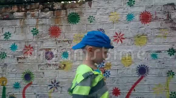 一个男孩走在白色砖墙上视频的预览图