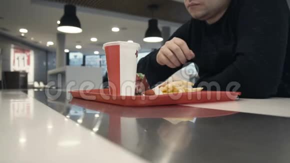 男子在快餐店吃薯条慢动作视频的预览图