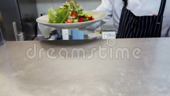 厨师在餐厅的厨房里给成品沙拉视频的预览图