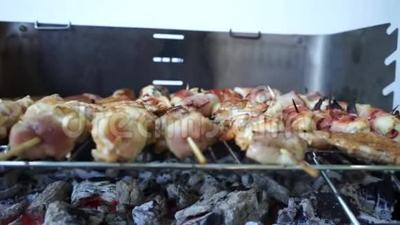 烤串上的烤肉串烧在烟卷上肉片美味的鸡肉和咸肉丸在烧烤上烹饪烧烤店视频的预览图