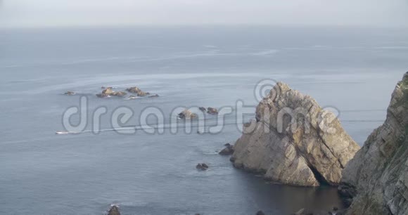 一艘摩托艇背着一群岩石横渡海总体景色视频的预览图