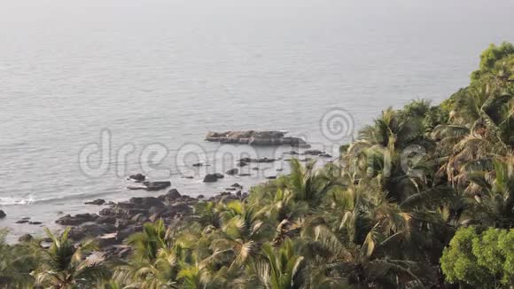 绿色棕榈丛林的海洋背景和海洋中的岩石鸟瞰视频的预览图