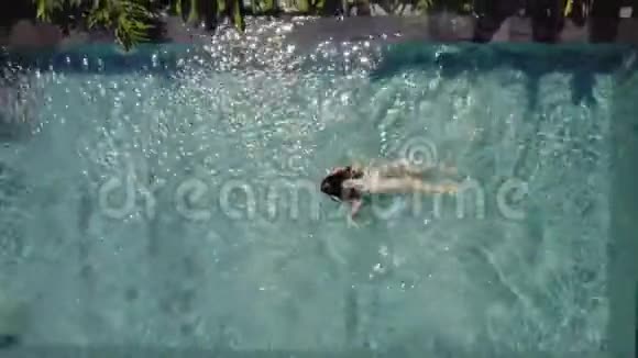 布鲁内特女孩在热带植物别墅的室外游泳池游泳视频的预览图