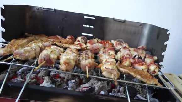 烤串上的烤肉串烧在烟卷上肉片美味的鸡肉和咸肉丸在烧烤上烹饪烧烤店视频的预览图