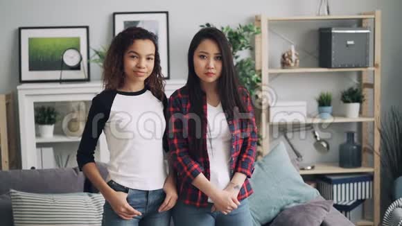 亚洲和非洲裔美国朋友在家摆姿势拍照时的慢镜头肖像视频的预览图