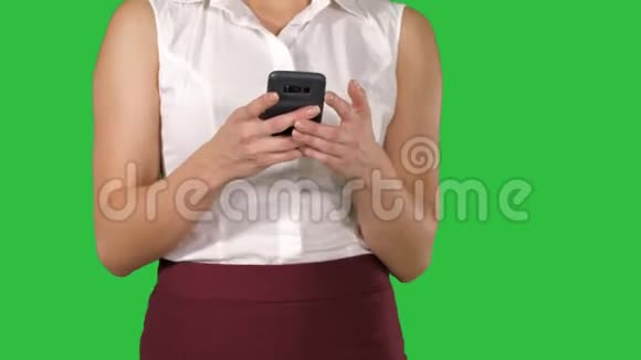 美丽的女人使用手机女人手在智能手机上的绿色屏幕上发短信Chroma键视频的预览图
