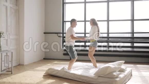 亲爱的在床上跳着双手抱着他们的新公寓关系概念视频的预览图