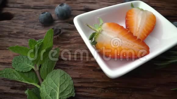 放在白色盘子里的草莓用新鲜酸奶浇水健康饮食观念视频的预览图