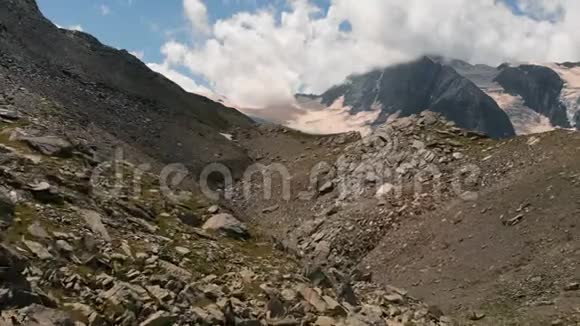 4k夏季云下落基山脉的雪峰空中行动视频的预览图