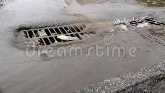 一个城市里的大雨淹没了街道和下水道的井盖视频的预览图