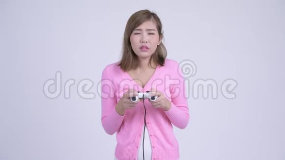 年轻疲惫的亚裔女子玩游戏睡着了视频的预览图