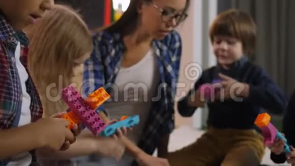 快乐的孩子们玩五颜六色的玩具积木视频的预览图