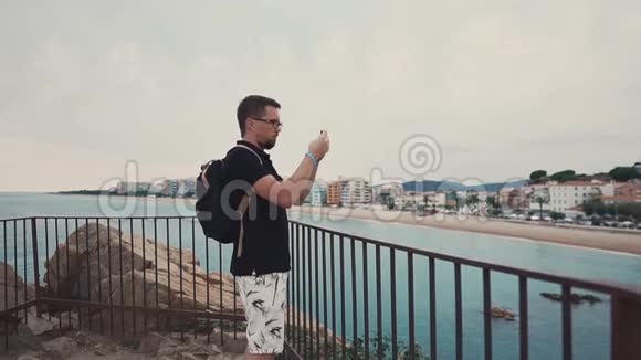 男性游客在智能手机上拍摄海滩视频的预览图