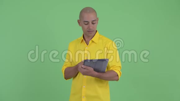 快乐英俊的秃头商人用数码平板电脑思考视频的预览图