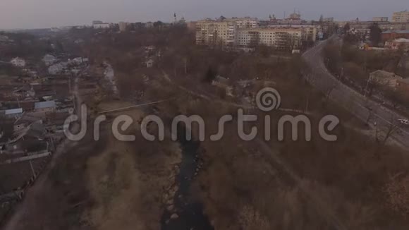 在小镇公路的郊区上空飞行的无人机视频的预览图