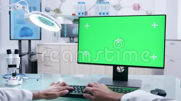 第一人称男性医生手在电脑上用绿色屏幕模拟打字视频的预览图