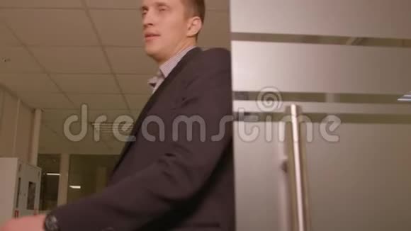 英俊的商人穿着西装走在走廊商务办公室视频的预览图