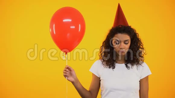 伤心的女孩拿着红色的气球在生日庆祝时感到沮丧和孤独视频的预览图
