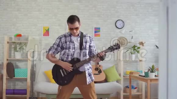 一位带眼镜的年轻音乐家情绪激动地弹着电吉他视频的预览图