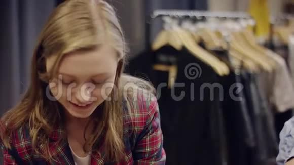 年轻可爱的女售货员给她的女客户送耳环她在服装店试穿视频的预览图